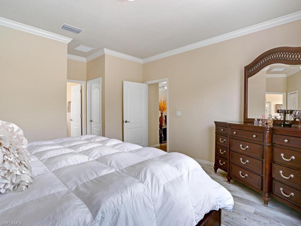 8143 Monticello Court Naples, FL 34104 - Photo 13 of 26 a bedroom with a bed and a dresser