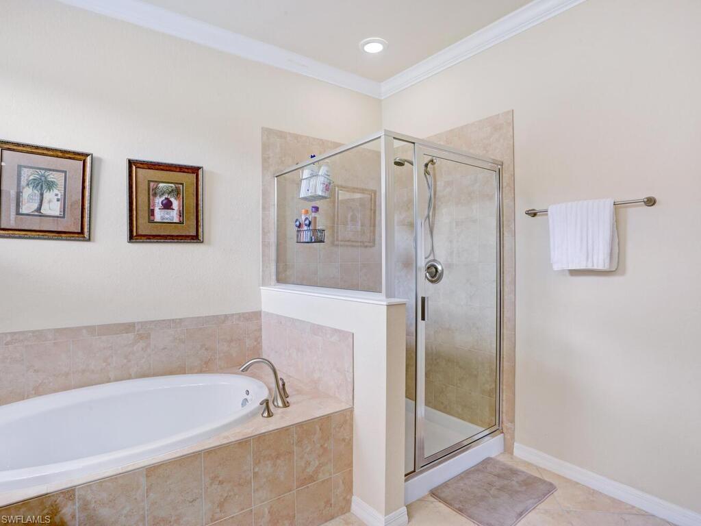 8143 Monticello Court Naples, FL 34104 - Photo 16 of 26 a bathroom with a bathtub and a shower