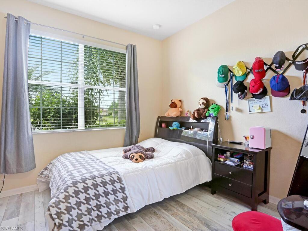 8143 Monticello Court Naples, FL 34104 - Photo 20 of 26 a bedroom with a bed dresser and a window