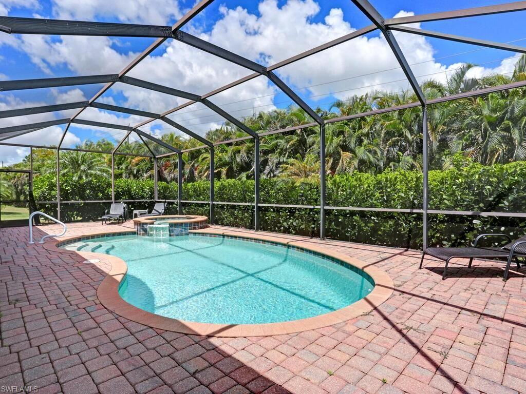 8143 Monticello Court Naples, FL 34104 - Photo 22 of 26 a view of a swimming pool with a patio