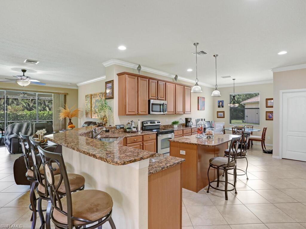 8143 Monticello Court Naples, FL 34104 - Photo 4 of 26 a large kitchen with a table and chairs