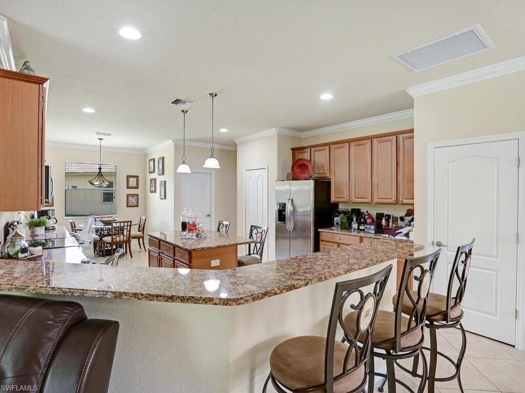 8143 Monticello Court Naples, FL 34104 - Photo 7 of 26 a kitchen with stainless steel appliances granite countertop a sink and a refrigerator
