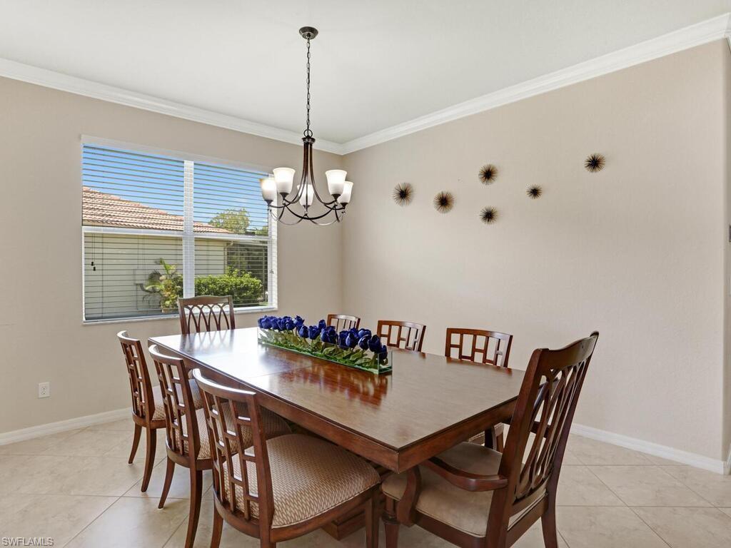 8143 Monticello Court Naples, FL 34104 - Photo 8 of 26 a view of a dining room with furniture a chandelier and wooden floor