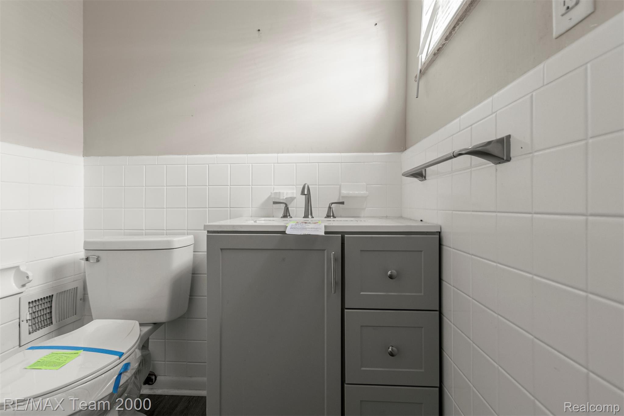 20295 Huntington Road Detroit, MI 48219 - Photo 30 of 43 Bathroom featuring vanity, tile walls, and wainscoting