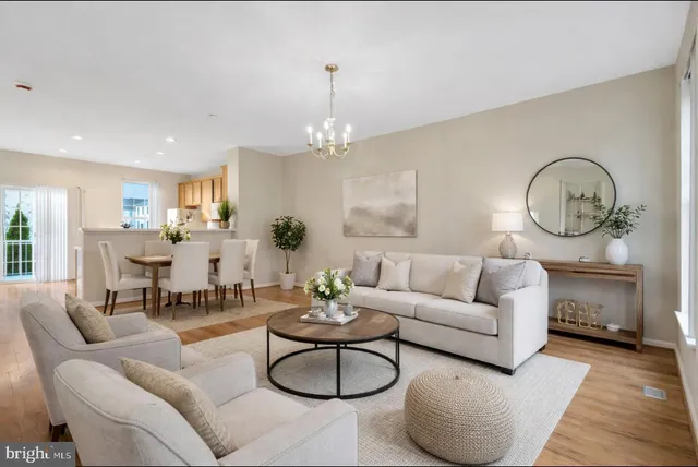 a living room with furniture a rug potted plant and a window