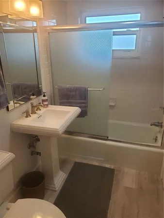 a bathroom with a sink mirror and toilet