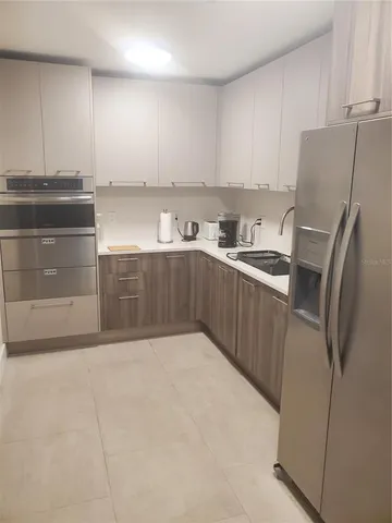 a kitchen with stainless steel appliances a refrigerator sink and cabinets