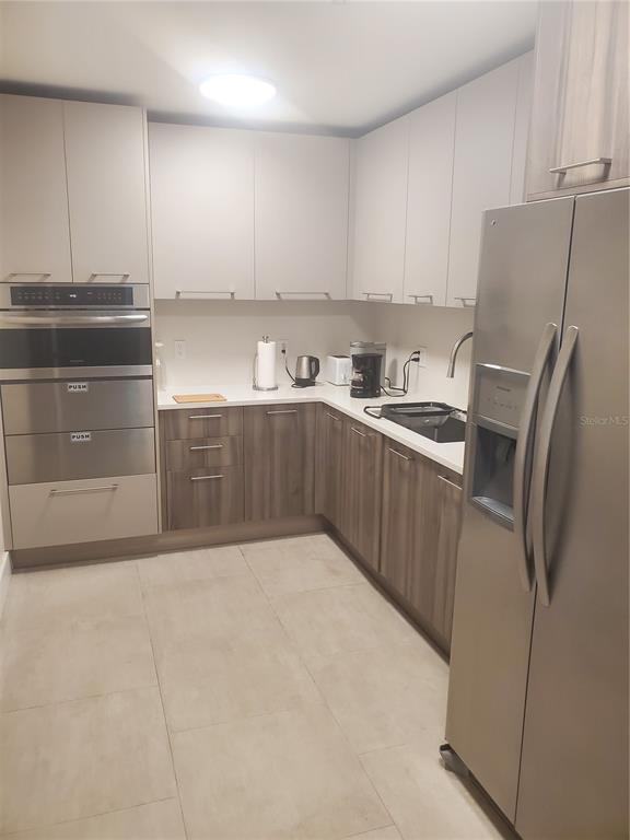 4401 Gulf Of Mexico Drive, Unit 703 Longboat Key, FL 34228 - Photo 16 of 23 a kitchen with stainless steel appliances a refrigerator sink and cabinets