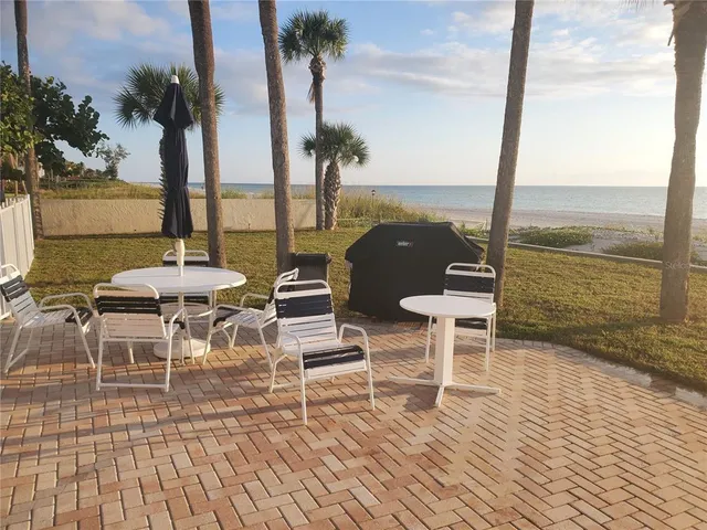 a view of a balcony with chairs and table on the wooden floor