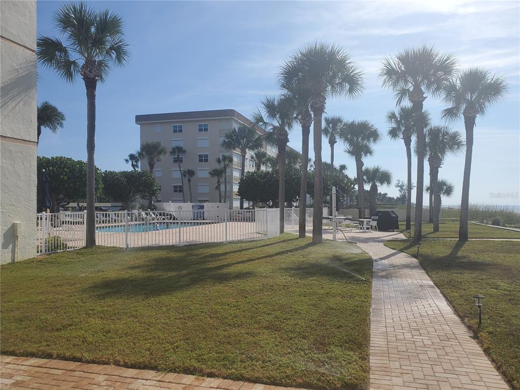 4401 Gulf Of Mexico Drive, Unit 703 Longboat Key, FL 34228 - Photo 21 of 23 a swimming pool with outdoor seating and yard