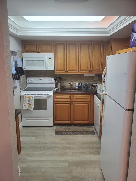 4401 Gulf Of Mexico Drive, Unit 703 Longboat Key, FL 34228 - Photo 10 of 23 a kitchen with a stove a refrigerator and a sink