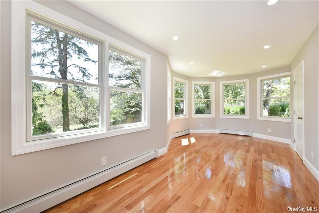 87 Dunlop Road Huntington, NY 11743 - Photo 11 of 31 a view of an empty room with wooden floor and a window