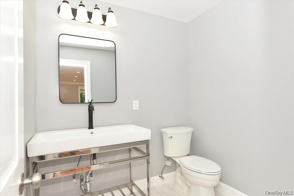 87 Dunlop Road Huntington, NY 11743 - Photo 15 of 31 a bathroom with a toilet sink and mirror
