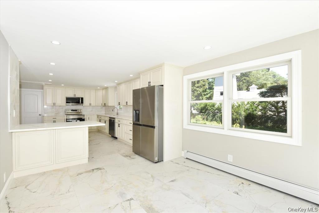 87 Dunlop Road Huntington, NY 11743 - Photo 10 of 31 a kitchen with refrigerator and cabinets