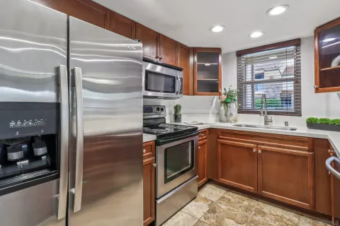 a kitchen with stainless steel appliances granite countertop a refrigerator and a sink