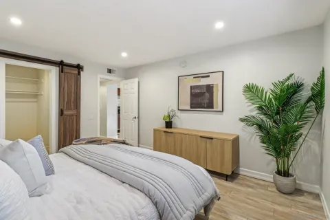 a bedroom with a large bed and a potted plant