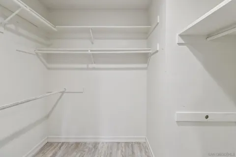 a view of walk in closet with empty racks