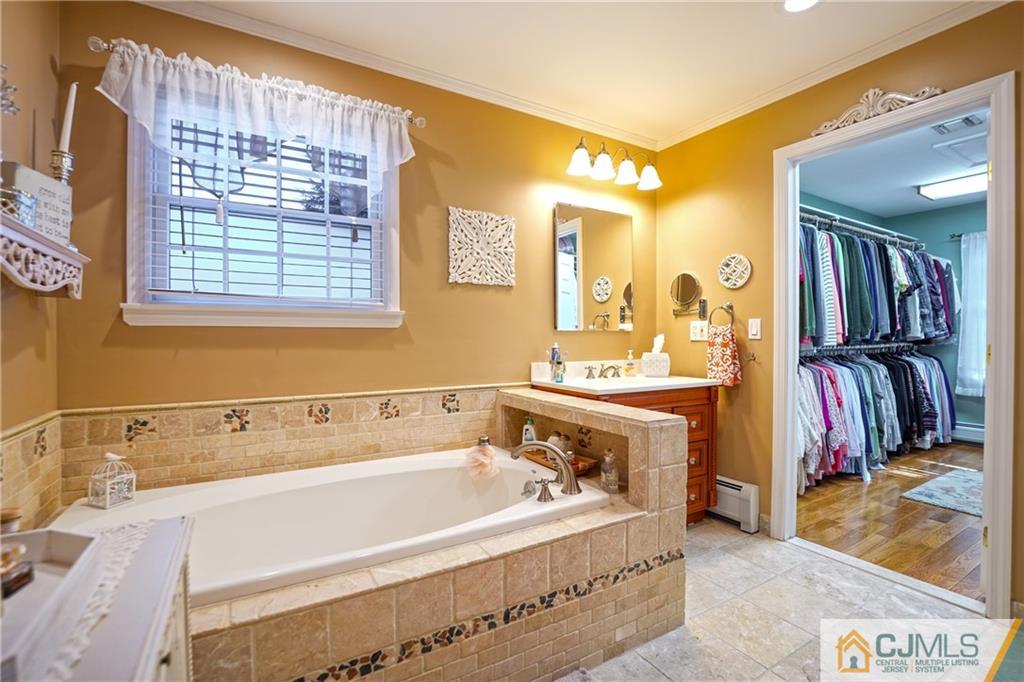 36 Starkin Road Edison, NJ 08837 - Photo 32 of 45 a bathroom with a tub a sink and a mirror