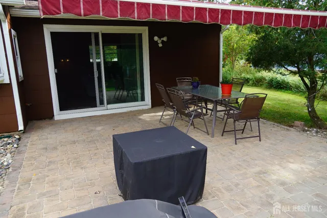 a patio with table and chairs and potted plants