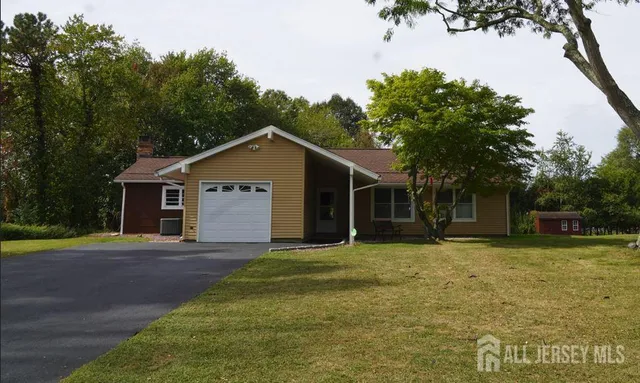 a front view of a house with a yard and trees