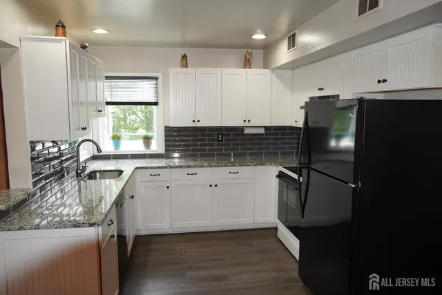 a kitchen with stainless steel appliances granite countertop a refrigerator sink and stove