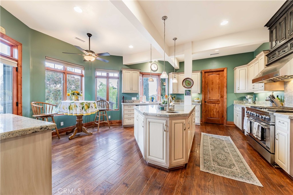26525 Carancho Road Temecula, CA 92590 - Photo 15 of 64 a large kitchen with kitchen island a large counter space a sink a window and stainless steel appliances