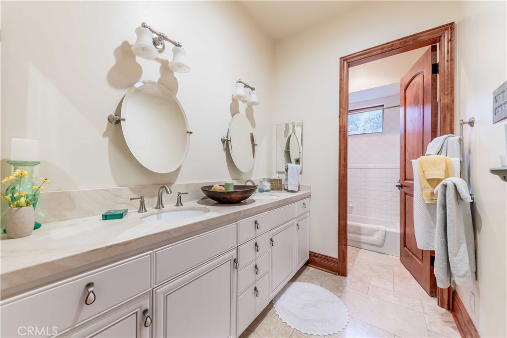 26525 Carancho Road Temecula, CA 92590 - Photo 32 of 64 a bathroom with a double vanity sink and a mirror