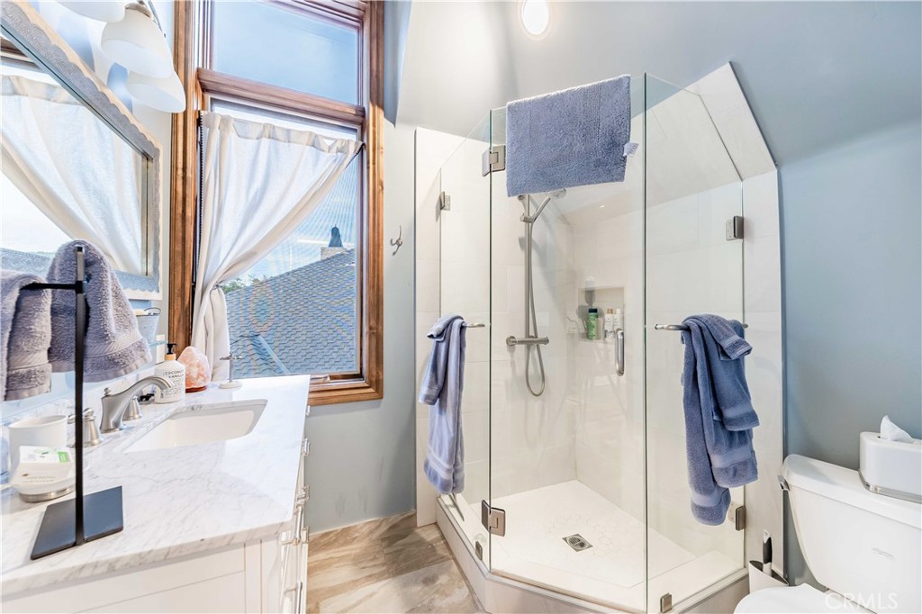 26525 Carancho Road Temecula, CA 92590 - Photo 40 of 64 a bathroom with a glass shower door and a sink