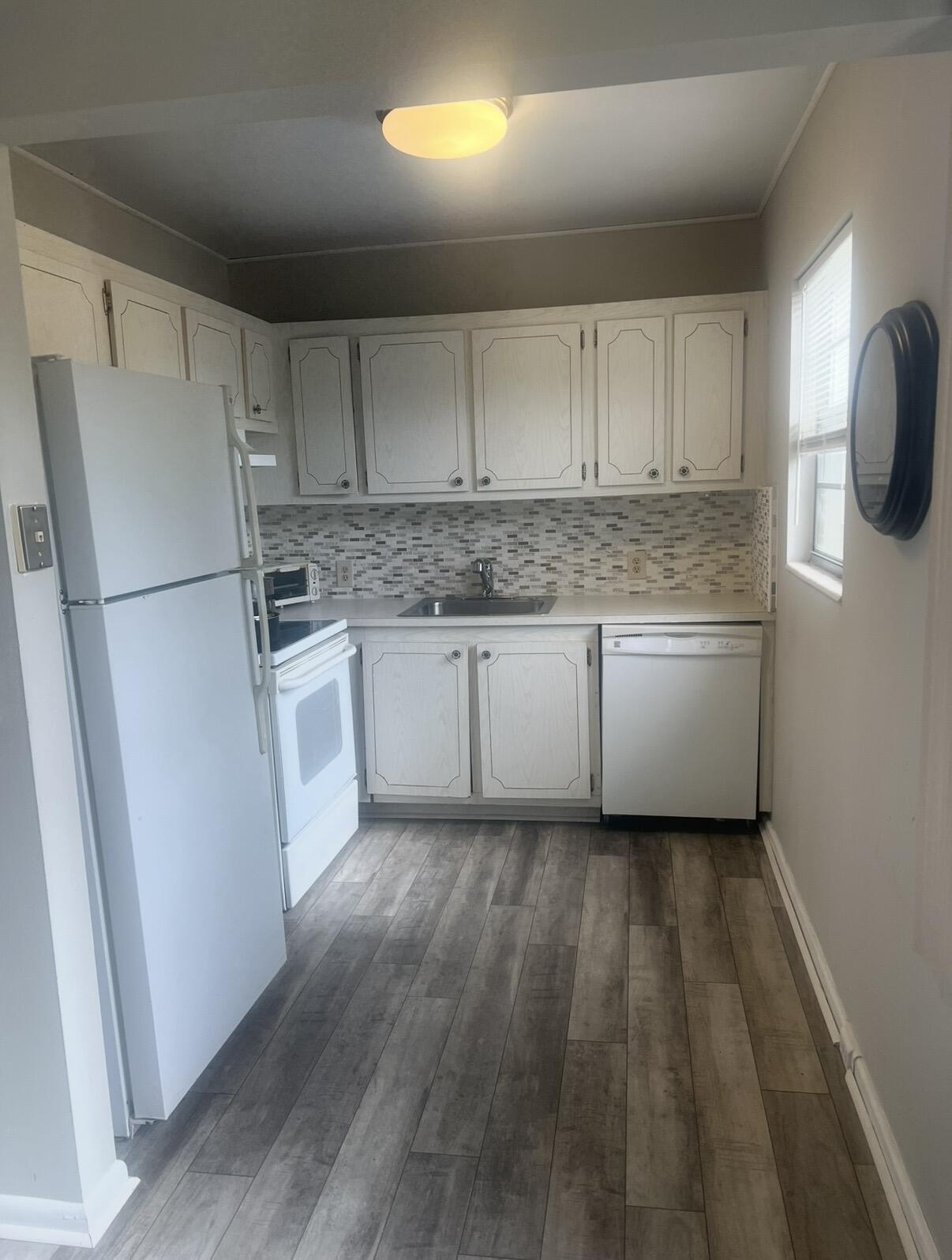 a kitchen with a refrigerator sink and cabinets