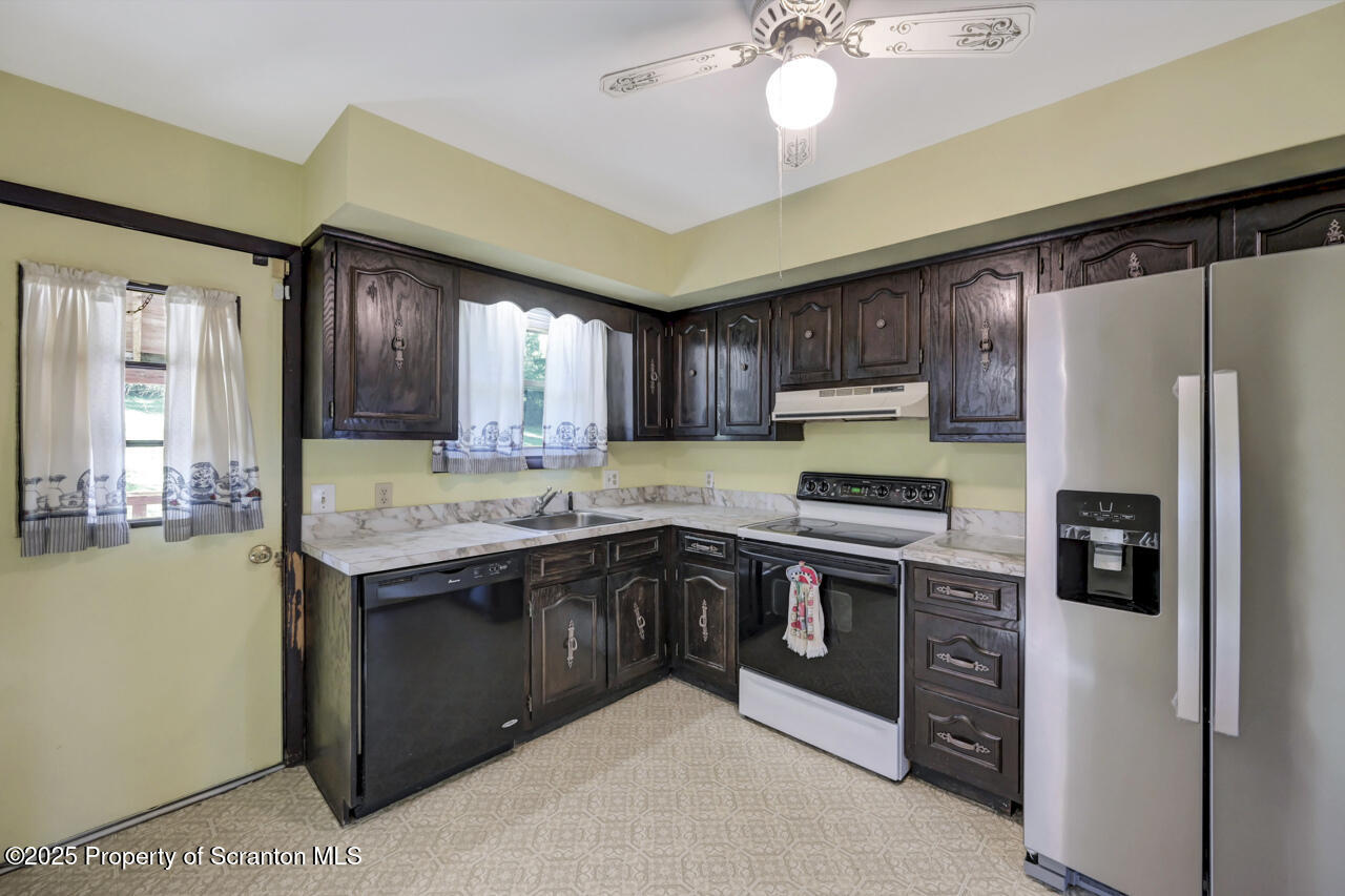 446 Maple Grove Road Moscow, PA 18444 - Photo 19 of 51 a kitchen with stainless steel appliances granite countertop a stove refrigerator and cabinets