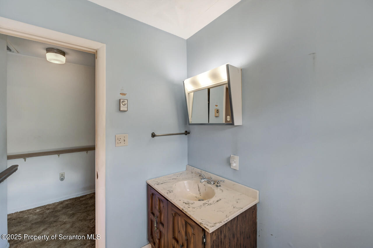 446 Maple Grove Road Moscow, PA 18444 - Photo 28 of 51 a bathroom with a sink a mirror and vanity