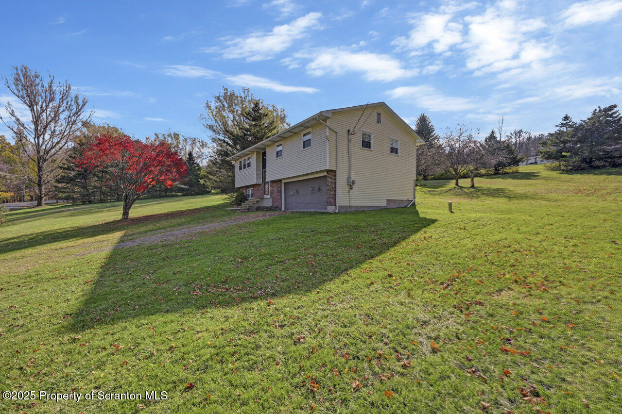 446 Maple Grove Road Moscow, PA 18444 - Photo 49 of 51 a backyard of a house with lots of green space and lake view