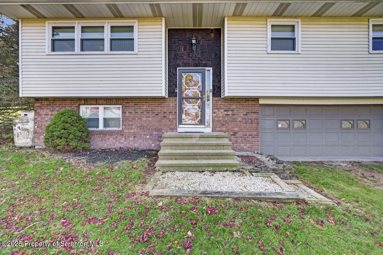 446 Maple Grove Road Moscow, PA 18444 - Photo 7 of 51 a front view of a house with garden