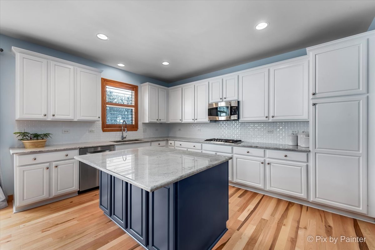 488 Newcastle Drive Cary, IL 60013 - Photo 13 of 33 a kitchen with wooden cabinets granite counter tops and a window