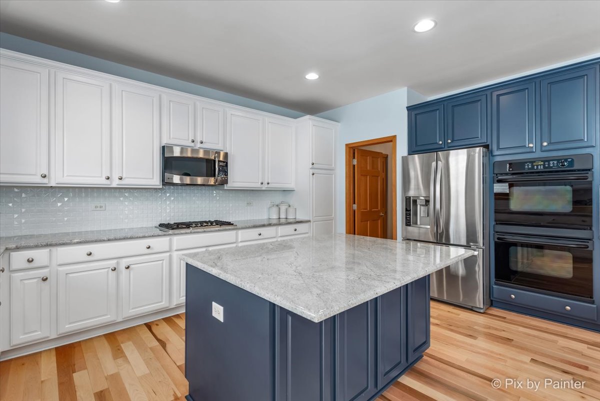 488 Newcastle Drive Cary, IL 60013 - Photo 16 of 33 a kitchen with wooden cabinets and stainless steel appliances