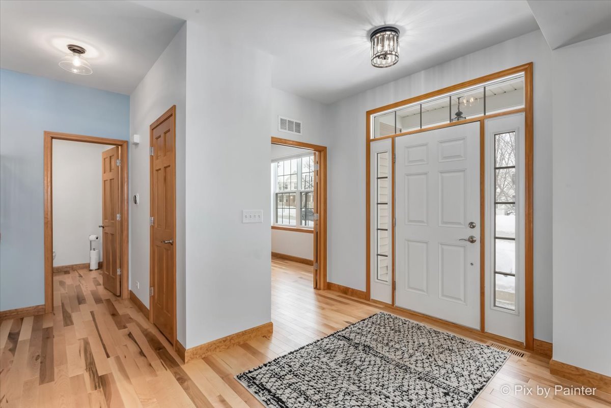 488 Newcastle Drive Cary, IL 60013 - Photo 2 of 33 a view of a hallway with wooden floor and a bathroom