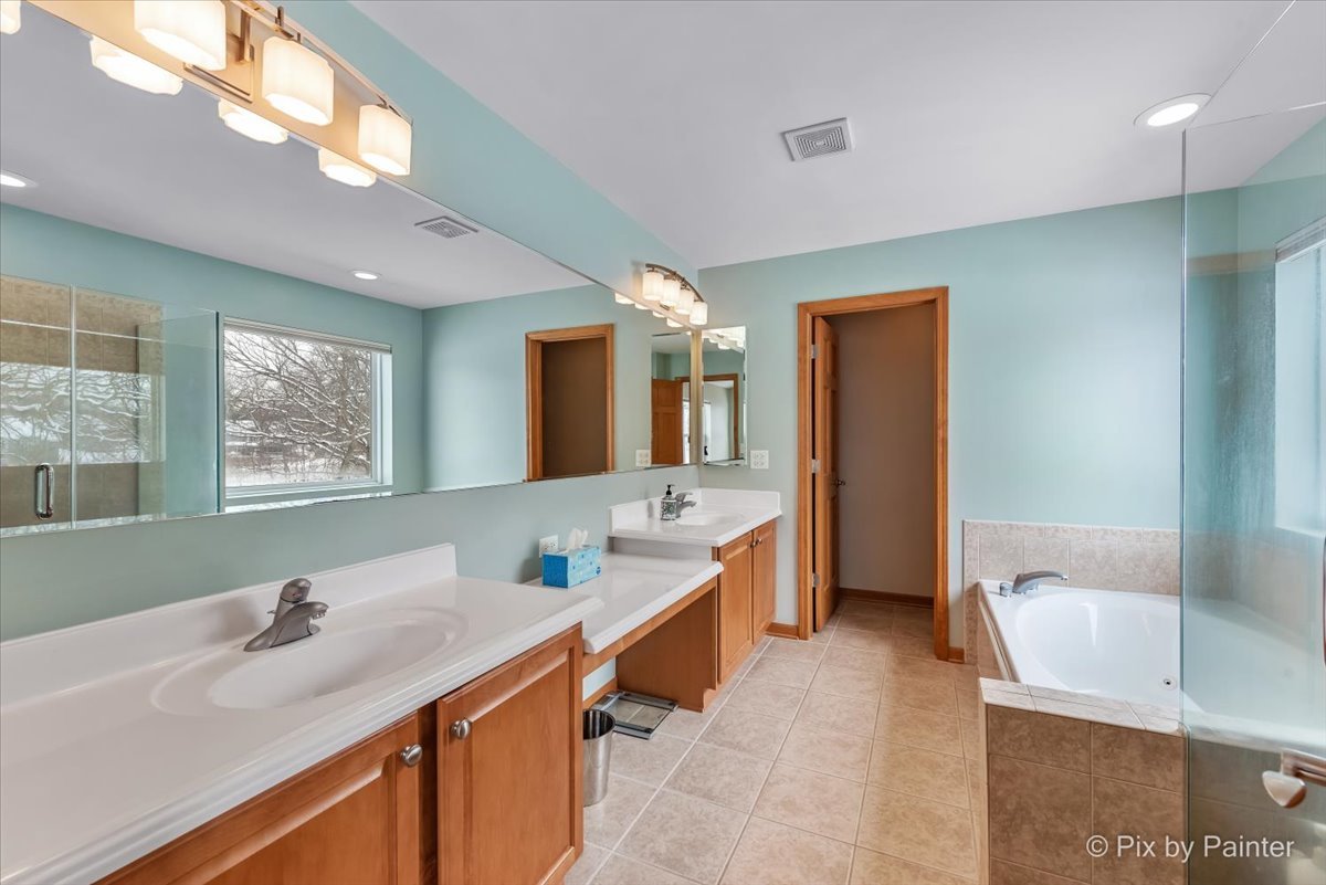 488 Newcastle Drive Cary, IL 60013 - Photo 23 of 33 a bathroom with a tub sink and mirror
