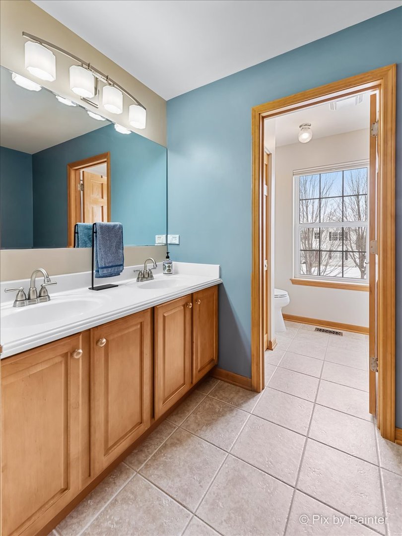 488 Newcastle Drive Cary, IL 60013 - Photo 28 of 33 a spacious bathroom with a double vanity sink and a mirror