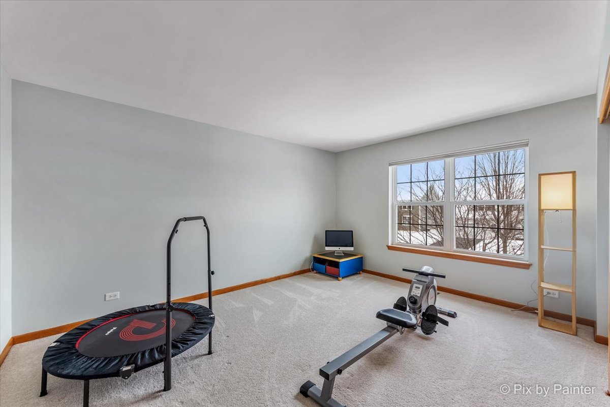 488 Newcastle Drive Cary, IL 60013 - Photo 30 of 33 a room with gym equipment and a large window