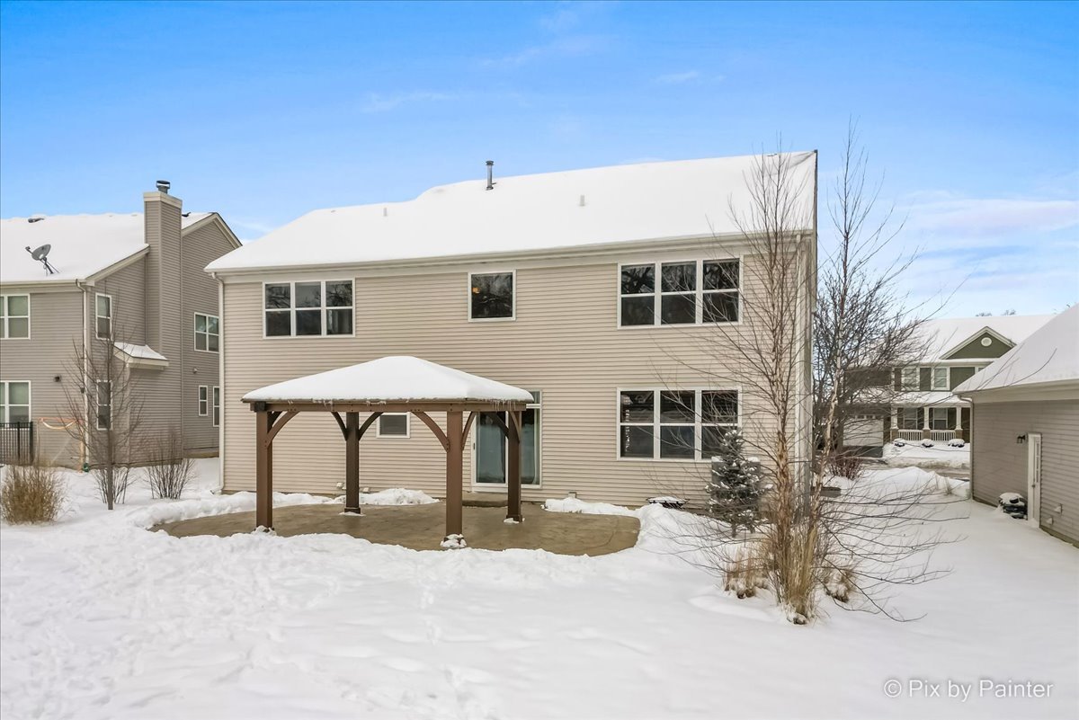 488 Newcastle Drive Cary, IL 60013 - Photo 31 of 33 a patio with a table and chairs under an umbrella