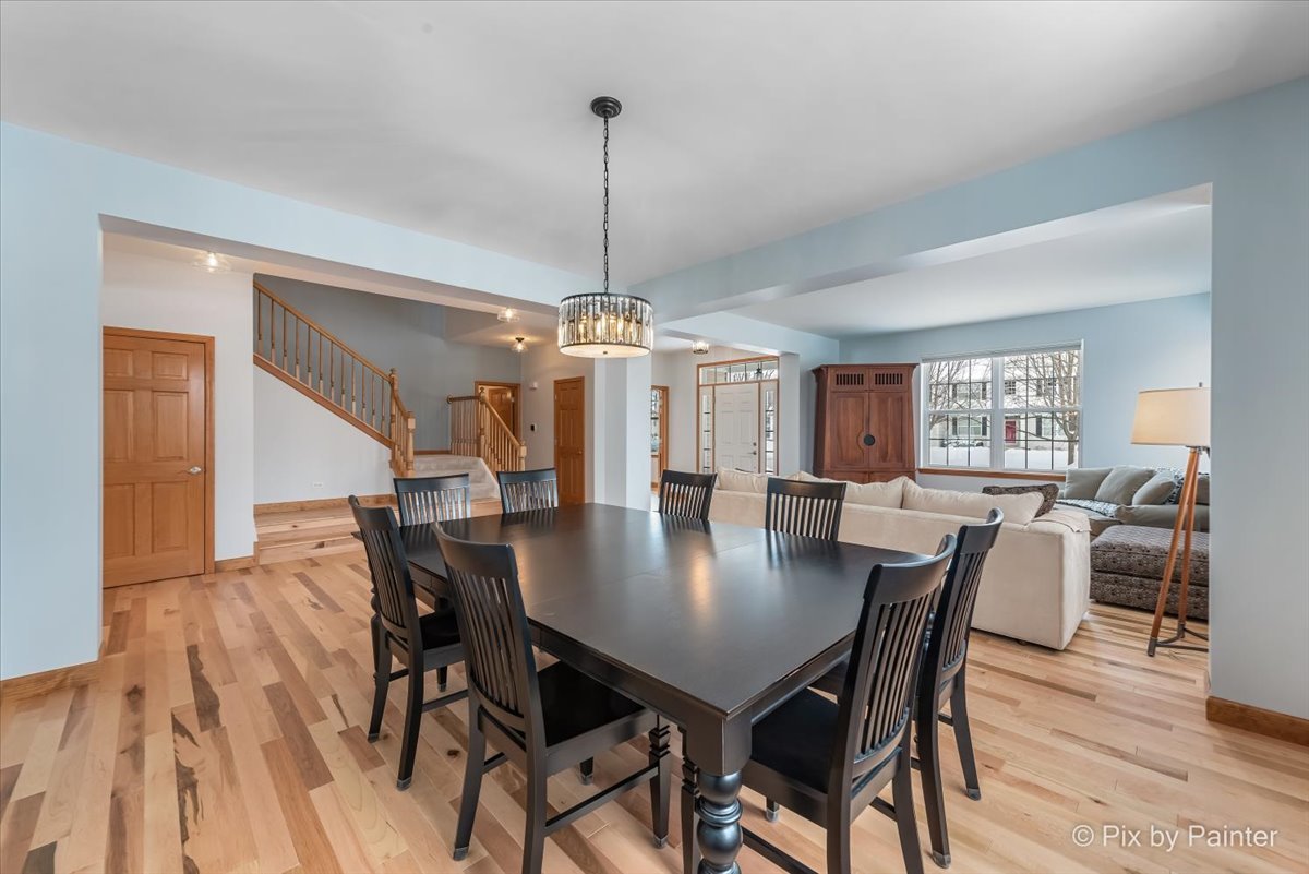 488 Newcastle Drive Cary, IL 60013 - Photo 8 of 33 a view of a dining room and livingroom with furniture wooden floor a chandelier