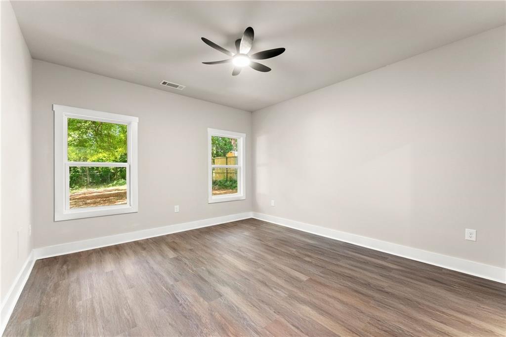 43 Anderson Street Jefferson, GA 30549 - Photo 17 of 45 an empty room with wooden floor ceiling fan and windows