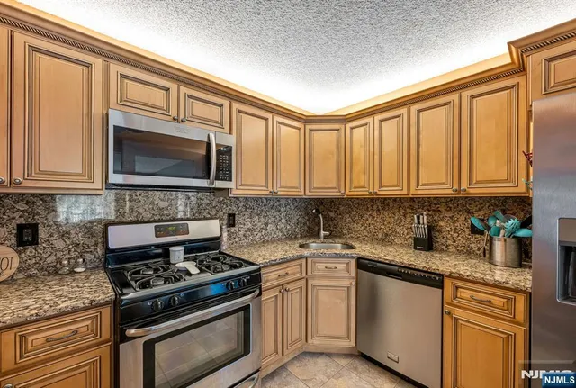 a kitchen with stainless steel appliances granite countertop a stove microwave sink and cabinets