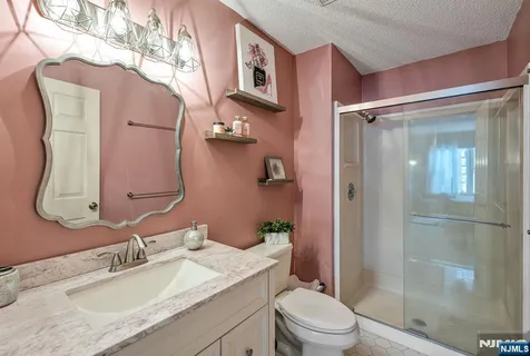 a bathroom with a granite countertop sink toilet and shower
