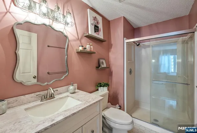 a bathroom with a granite countertop sink toilet and shower