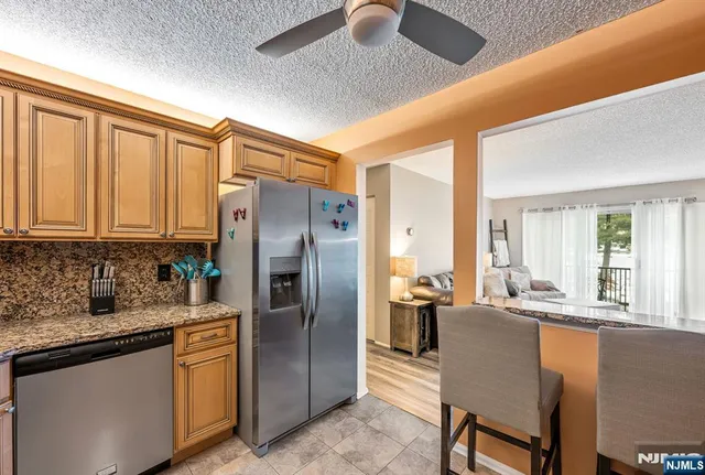 a kitchen with stainless steel appliances granite countertop a refrigerator a sink a stove and island