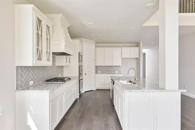 a kitchen with stainless steel appliances a sink stove and cabinets