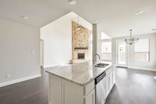 a kitchen with granite countertop a sink and a wooden floor