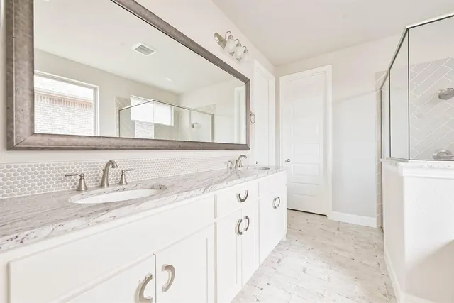 a bathroom with double sink and a mirror
