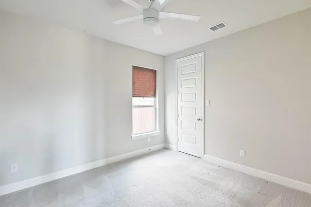 an empty room with windows and closet area